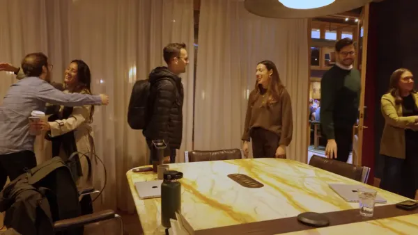 Team members greeting each other around a conference table after an acquisition meeting